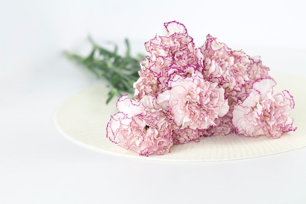 Anjo branco na mesa. Lindas flores cor de rosa na mesa branca.