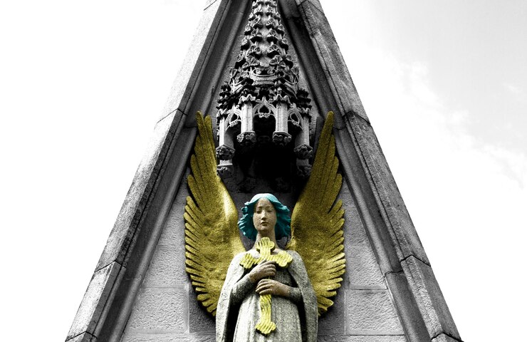 Foto anjo com asas douradas segurando a cruz