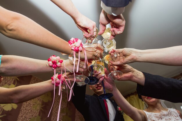 Anklopfen der Gläser bei der Hochzeit. Hochzeitsgäste, die Champagner trinken