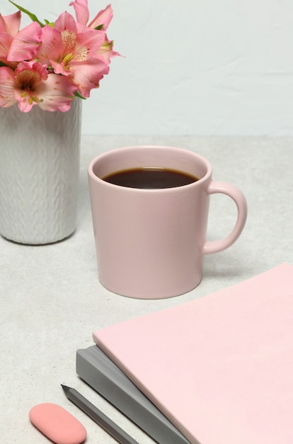 Anmerkungsbücher, Bleistift, Kaffeetasse, Blumenstraußblumen auf Steintabelle