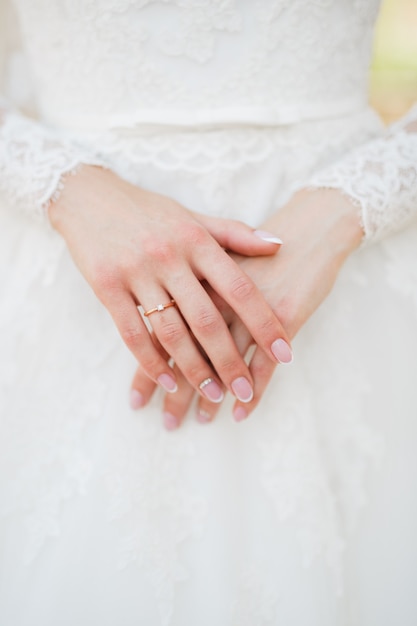 Anmutige Hände der Braut mit Ehering am Finger