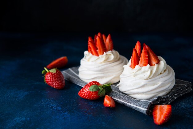 Anna Pavlova Kuchen mit Sahne und frischen Erdbeeren auf einem dunklen Hintergrund, Kopienraum