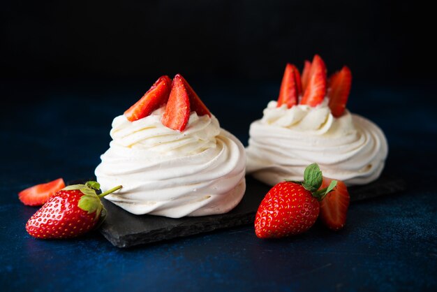 Anna Pavlova Kuchen mit Sahne und frischen Erdbeeren auf einem dunklen Hintergrund