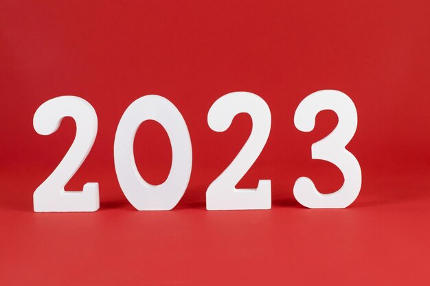 Año 2023 números blancos de madera sobre un fondo rojo. Lugar para el texto. Copie el concepto de espacio, vacaciones.