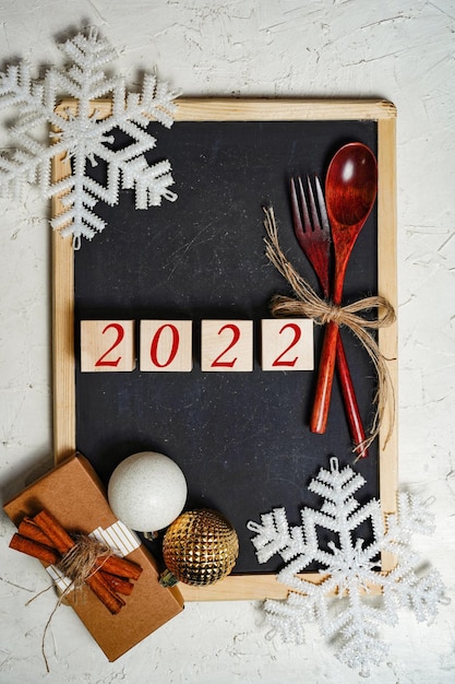 Ano em um fundo de natal, cozinha, decorações de natal, flocos de neve, um presente e um quadro negro.