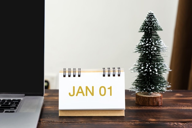 Ano Novo 01 de janeiro na mesa de escritório com laptop e árvore de Natal
