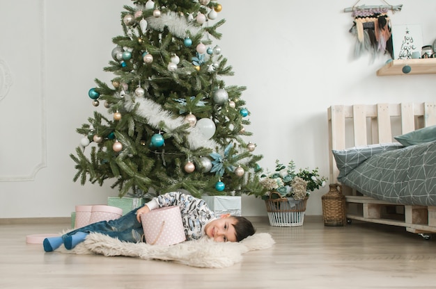 Foto ano novo conceito, um menino perto de uma árvore de natal