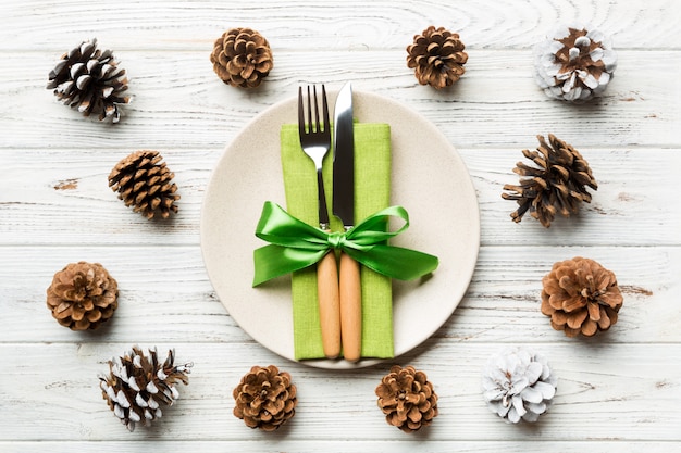 Ano novo conjunto de prato e utensílio em fundo de madeira. Vista superior do jantar de férias decorado com pinhas. época de Natal