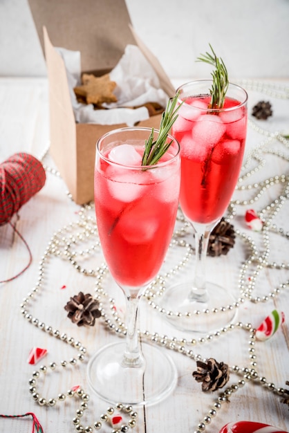 Año Nuevo, bebidas navideñas. Cóctel de alcohol rojo con arándano, licor, romero, con hielo.