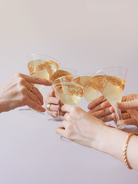 año nuevo celebrando las manos con copas de vino espumoso blanco