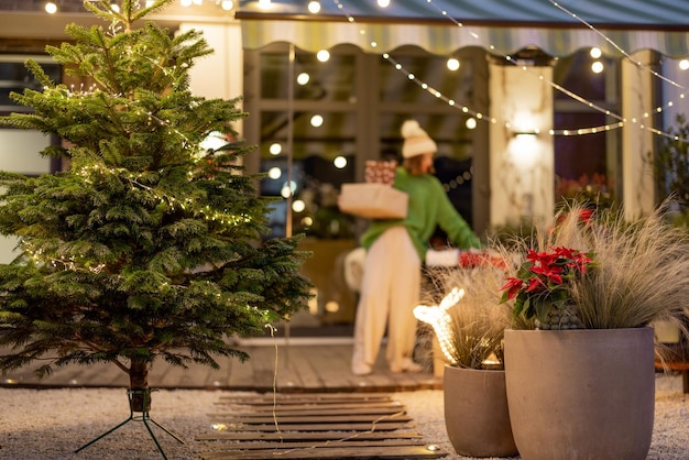 Año nuevo decorado patio trasero con una mujer caminando con regalos