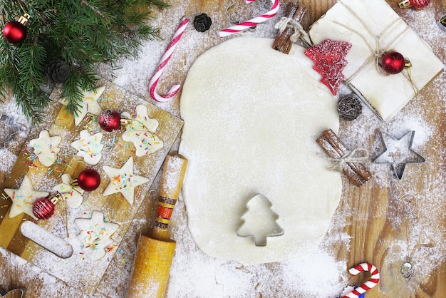 Año nuevo manjar cocinar galletas de mantequilla de diferentes formas en una mesa de madera con accesorios navideños