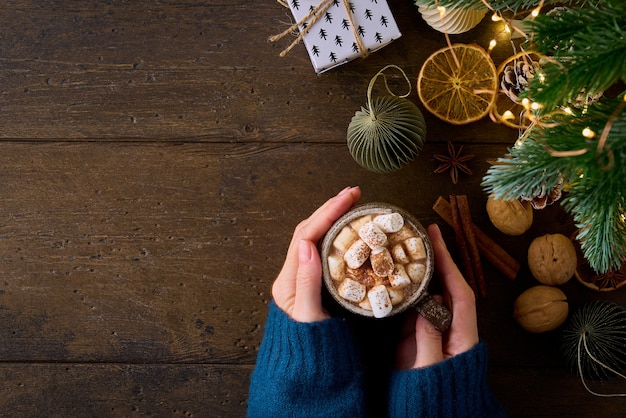 Anonyme Frau hält Tasse heiße Schokolade mit Marshmallows Weihnachtsschmuck