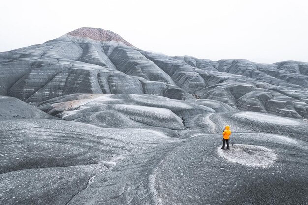 Anonymer Backshot-Abenteurer mit orangefarbener Jacke in kalter Tundra