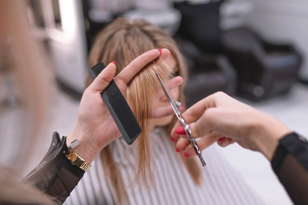 Anonymer Friseur, der Haar des Kunden schneidet