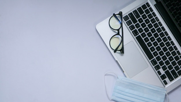 Anordnung der flachen Tischelemente mit Laptop und Maske