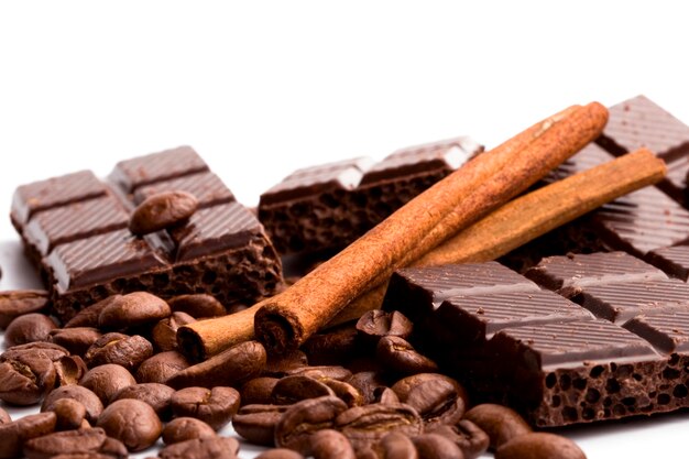 Anordnung für Schokolade, Kaffee und Zimtstangen auf Weiß