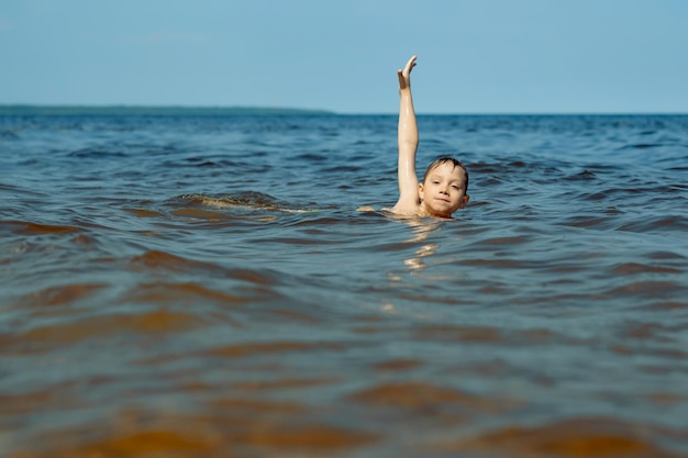 Años lindo niño caucásico nadando en el mar