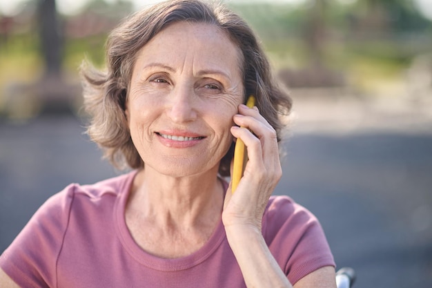 Anruf. Lächelnde Frau, die am Telefon spricht