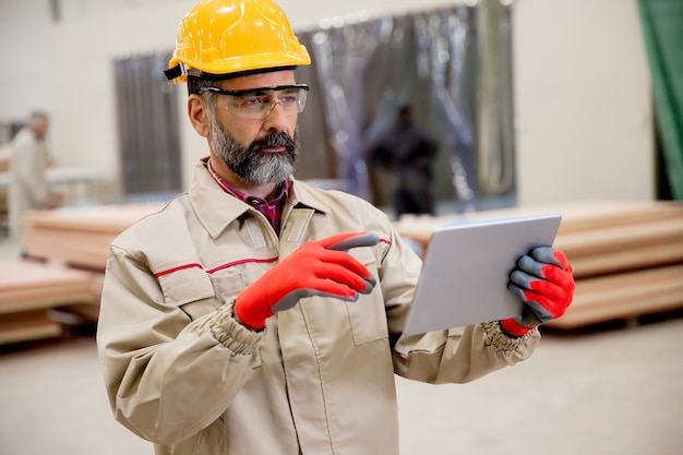 Ansicht am älteren Mann, der in der Fabrik arbeitet