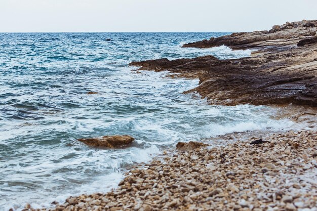 Ansicht des felsigen Meeresstrandes im Sturmwetter-Kopienraumhintergrund