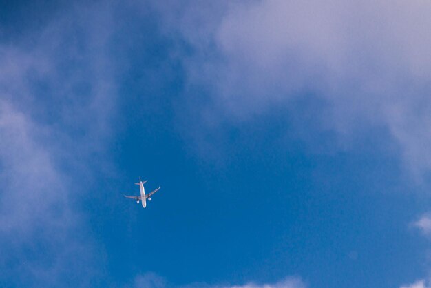 Ansicht des Flugzeugs vom blauen Himmel des Bodenreisekonzepts mit weißen Wolken