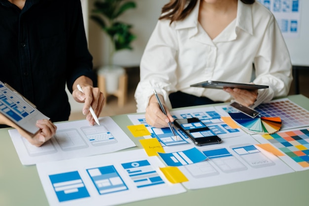 Ansicht des UI-Entwicklerteams beim Brainstorming für ihr Projekt mit Laptop, Smartphone und digitalem Tablet Creative Digital Development AgencyxA