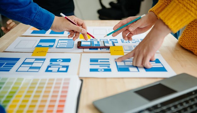 Ansicht des UI-Entwicklerteams beim Brainstorming für ihr Projekt mit Laptop, Smartphone und digitalem Tablet Creative Digital Development AgencyxA