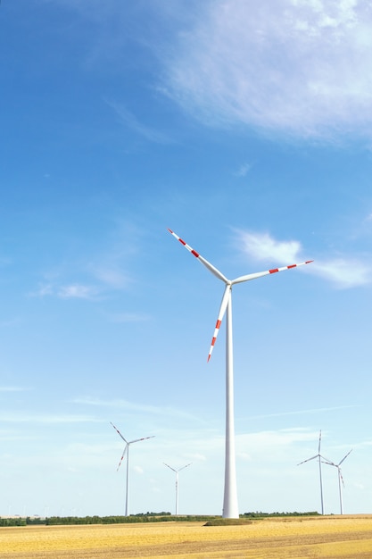 Ansicht einer Windkraftanlage auf einem Hintergrund des blauen Himmels und der Felder mit Kornernten.