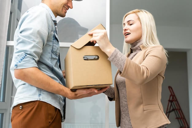 Ansicht eines Lieferers, der dem Kunden ein Paket überreicht