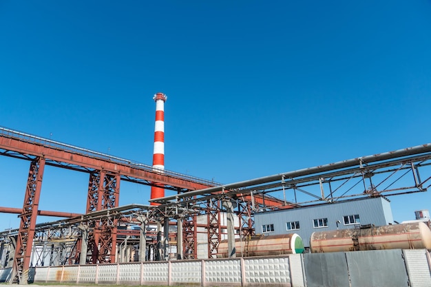 Ansicht eines Wärmekraftwerks oder einer Fabrik zur Herstellung und Verarbeitung von Erdölprodukten Große Industrieschornsteine vor einem strahlend blauen Himmel Entfernung der Verbrennung