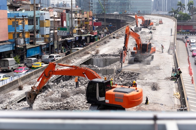 Ansicht über Landstraßenbau-Straßenarbeiten mit rotem Bagger.