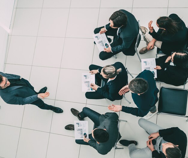 Ansicht von oben. Arbeitsgruppe mit Finanzdokumenten im Konferenzraum.