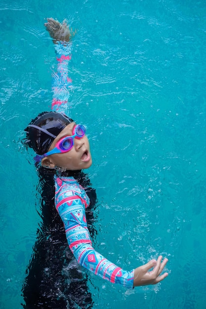 Ansicht von oben Asiatisches Kind kleines Mädchen lernen, Freistil im Schwimmbad zu schwimmen