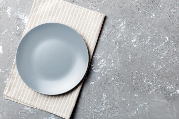 Ansicht von oben auf farbigem Hintergrund leere runde graue Platte auf Tischdecke für Lebensmittel Leere Schale auf Serviette mit Platz für Ihr Design