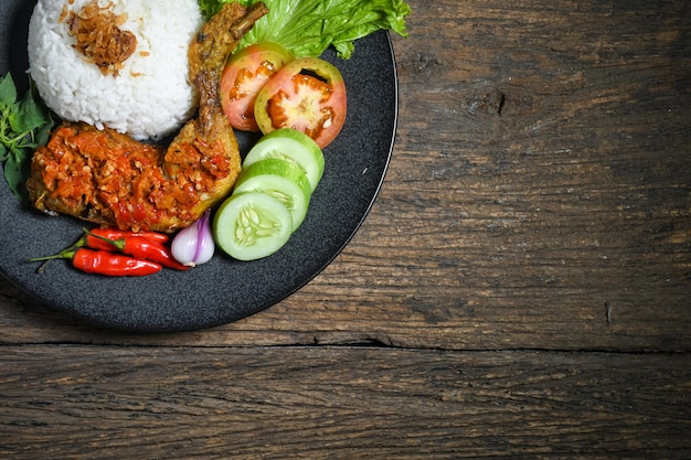 Ansicht von oben Ayam geprek indonesisches Essen oder geprek Brathähnchen mit scharfer Sambal-Chili-Sauce, serviert mit Reis