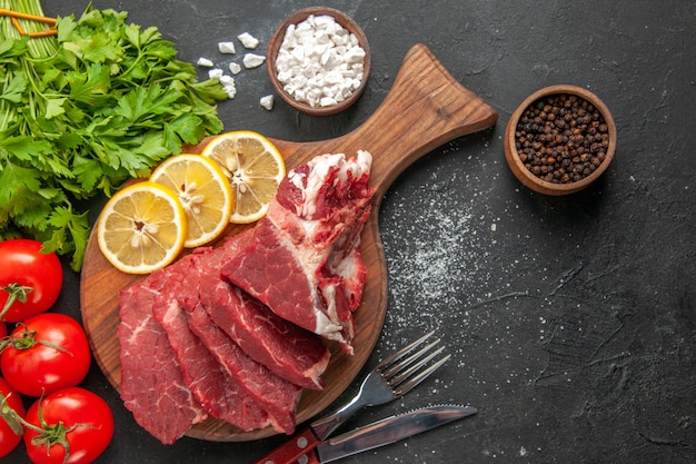 Ansicht von oben frisch geschnittenes Fleisch mit Zitronenscheiben und roten Tomaten