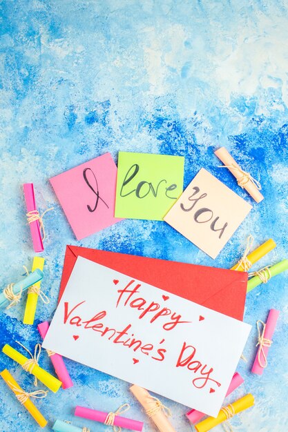 Ansicht von oben Ich liebe dich geschrieben auf Haftnotizen Scroll Wunschpapiere Happy Valentinstag auf Papier auf blauem Hintergrund geschrieben