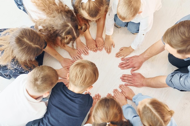 Foto ansicht von oben mann mit seinen kindern studenten in händchen haltend für den erfolg konzeption der bildung