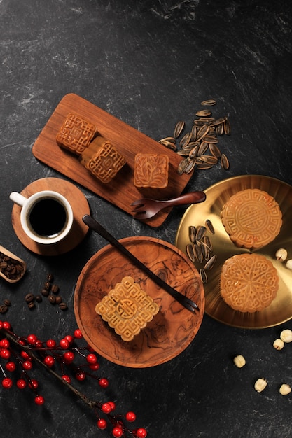 Ansicht von oben Verschiedene Form Moon Cake (Mooncake) Chinesischer Dessert-Snack während des Mondneujahres Mitte Herbstfest. Concept Rustica Black Asian Bakery, serviert mit Tee und Kaffee