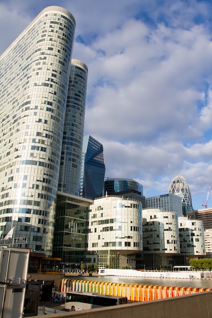 Ansicht von unten der Glaswolkenkratzer des Geschäftsgebiets von Paris La Defense gegen einen blauen bewölkten Himmel