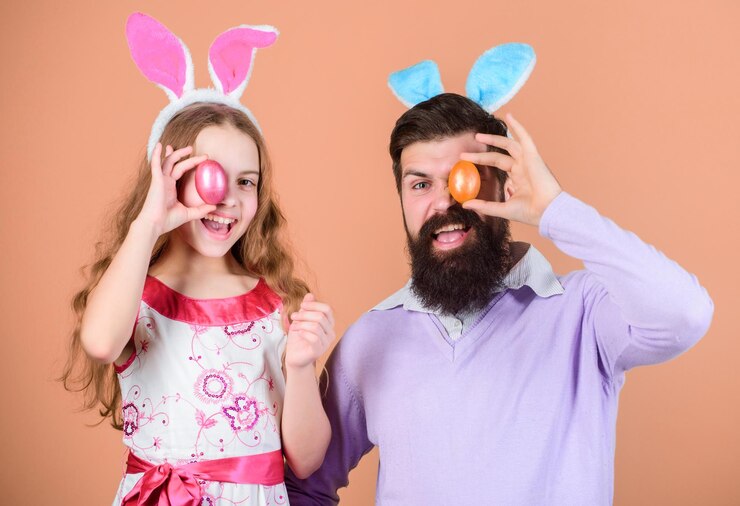 Foto ansiosos para celebrar a páscoa celebração familiar pai e filho com ovos de páscoa coloridos família de pai e filha em orelhas de coelho da páscoa família feliz família na caça anual aos ovos de páscoa