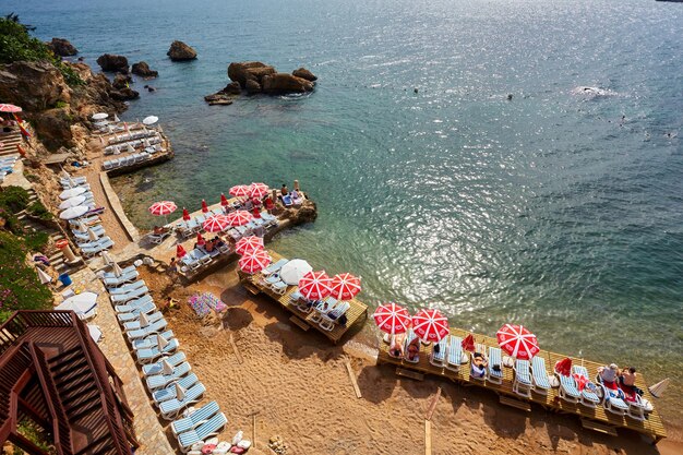 Antalya Turquia Pessoas na praia tomando sol nas espreguiçadeiras perto da água