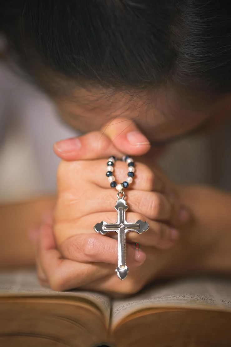 Foto antecedentes do cristianismo do rosário de jesus cruz nas mãos de mulher orando por bênção de deus