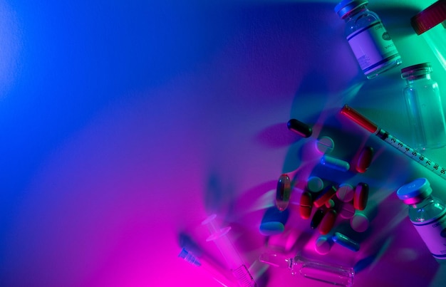 Antecedentes farmacêuticos Droga coronavírus Pesquisa de laboratório Vacina de luz de néon jab dose garrafa seringa pílulas arranjo de tubo de ensaio em espaço vazio colorido azul rosa brilhante