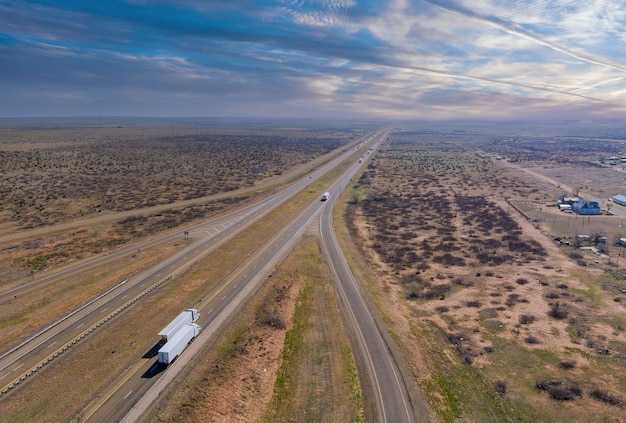 Antena de la carretera del desierto de una nueva carretera de dos carriles rodeada por un paisaje desértico cerca de San Jon, Nuevo México, EE.