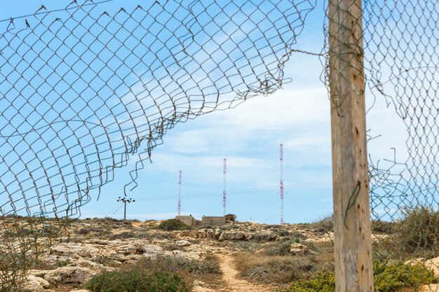 Antena de metal atrás da cerca