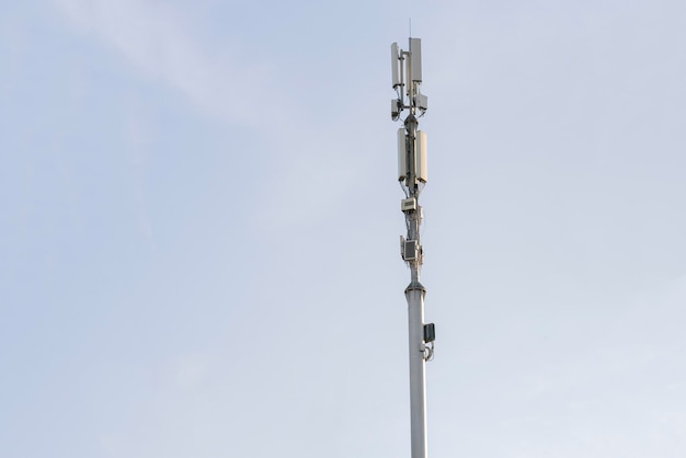 Una antena de estación 5g en la ciudad contra el receptor de la red del cielo