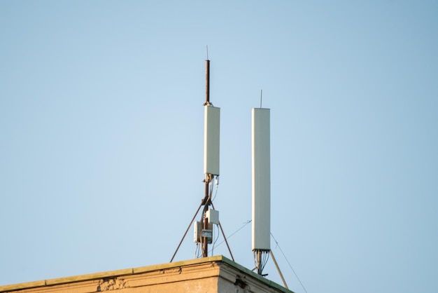 Antena moderna de estación de telecomunicaciones de televisión y teléfono inteligente 5g contra el cielo en las ciudades