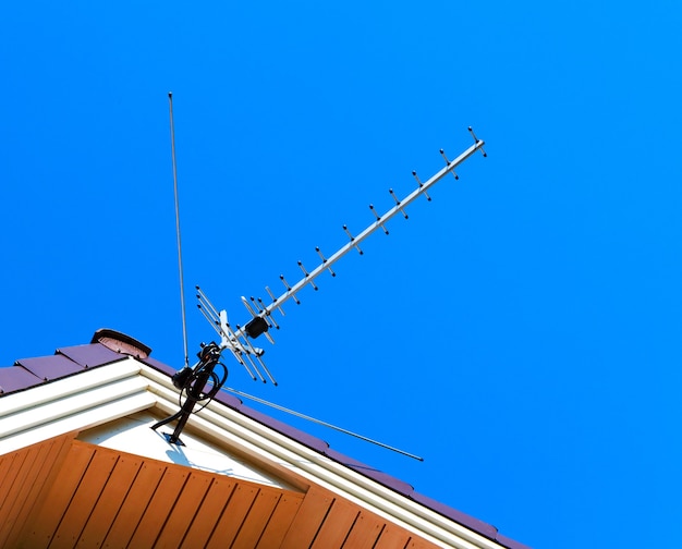 Antena no céu. Antena de televisão no telhado. Antena de tv.